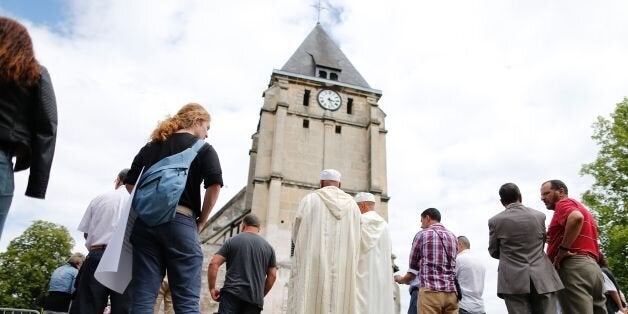 Muslims put flowers and hold a minute of silence on July 29, 2016 in front of the church if Saint-Etienne-du-Rouvray, western