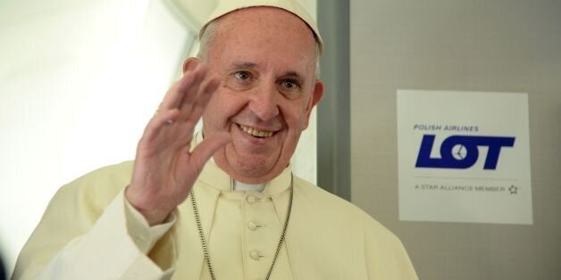 Pope Francis waves during a press conference on the plane after his visit to Krakow for the World Youth Days, on July 31, 201