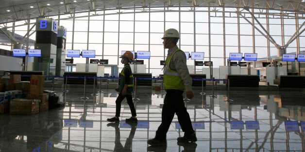 Workers leave the new terminal two wing at Noi Bai international airport in Hanoi December 20, 2014. Vietnam has started operating the new $900 million airport terminal that will nearly double the capital's flight capacity, the latest move in expanding what is one of the world's fastest-growing aviation markets. Photo taken on December 20, 2014. REUTERS/Kham (VIETNAM - Tags: BUSINESS CONSTRUCTION TRANSPORT)