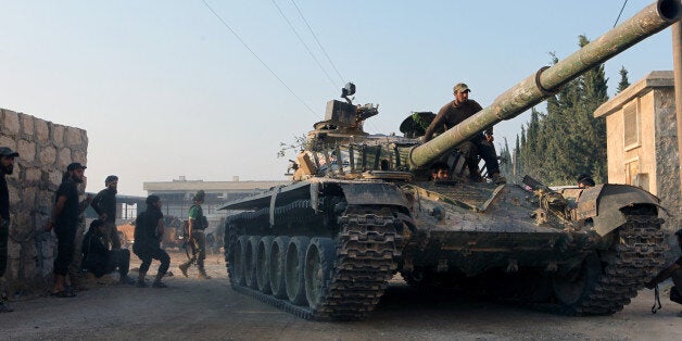 Rebel fighters ride a tank in an artillery academy of Aleppo, Syria, August 6, 2016. REUTERS/Ammar Abdullah