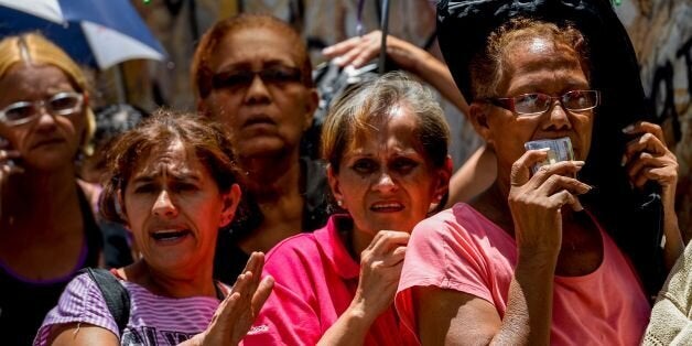 People line up to buy groceries outside at a supermarket in La Urbina neighborhood in Caracas, on July 13, 2016. Venezuela's military has been put on the frontline of a worsening national economic crisis by taking charge of food distribution and key ports amid dire shortages and mounting unrest. / AFP / FEDERICO PARRA (Photo credit should read FEDERICO PARRA/AFP/Getty Images)