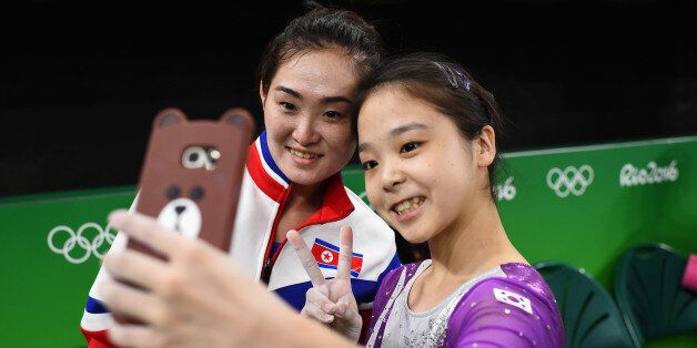 2016 Rio Olympics - Gymnastics training - Rio Olympic Arena - Rio de Janeiro, Brazil - 04/08/2016. Lee Eun-Ju (KOR) of South Korea (R) takes a selfie picture with Hong Un Jong (PRK) of North Korea. REUTERS/Dylan Martinez TPX IMAGES OF THE DAY. FOR EDITORIAL USE ONLY. NOT FOR SALE FOR MARKETING OR ADVERTISING CAMPAIGNS.