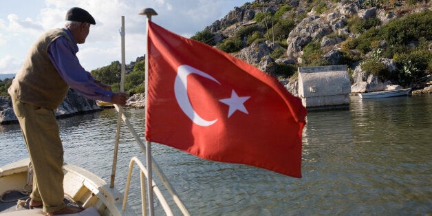 Senior fisherman with national flag and sunken tomb