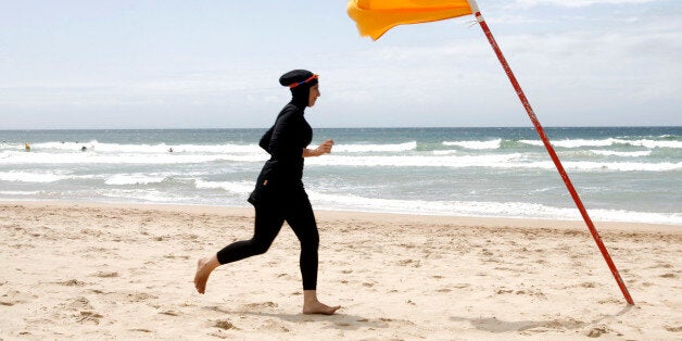 Twenty-year-old trainee volunteer surf life saver Mecca Laalaa runs along North Cronulla Beach in Sydney during her Bronze medallion competency test January 13, 2007. Specifically designed for Muslim women, Laalaa's body-covering swimming costume has been named the "burkini" by its Sydney based designer Aheda Zanetti. REUTERS/Tim Wimborne (AUSTRALIA)