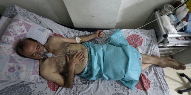 A man breathes through an oxygen mask at al-Quds hospital, after a hospital and a civil defence group said a gas, what they believed to be chlorine, was dropped alongside barrel bombs on a neighbourhood of the Syrian city of Aleppo, Syria, early August 11, 2016. REUTERS/Abdalrhman Ismail 