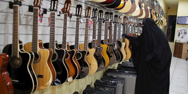 Gisele Marie, a Muslim woman and professional heavy metal musician, looks at guitars at a shop selling musical instruments in Sao Paulo August 13, 2015. Based in Sao Paulo, Marie, 42, is the granddaughter of German Catholics, and converted to Islam several months after her father passed away in 2009. Marie, who wears the Burka, has been fronting her brothers' heavy metal band "Spectrus" since 2012. "People do not expect to see a Muslim woman who uses a Burqa, practices the religion properly and is a professional guitarist who plays in a Heavy Metal band, so many people are shocked by it. But other people are curious and find it interesting, and others think that it is cool, but definitely, many people are shocked," said Marie. Picture taken August 13, 2015. REUTERS/Nacho Doce