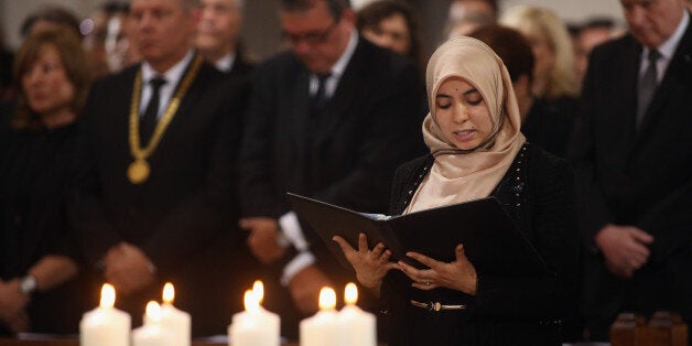 MUNICH, GERMANY - JULY 31: A Muslim woman prays in front of nine candles symbolizing the victims of a rampage shooting during a memorial service for the victims of last week's shooting spree that left nine victims dead on July 31, 2016 in Munich, Germany. David Ali Sonboly, an 18-year-old German of Iranian descent, killed nine people in a shooting spree near and in a shopping center before killing himself in a park. Investigators have found evidence Sonboly found inspiration in the 2011 mass shooting in Norway by Anders Breivik. (Photo by Johannes Simon/Getty Images)