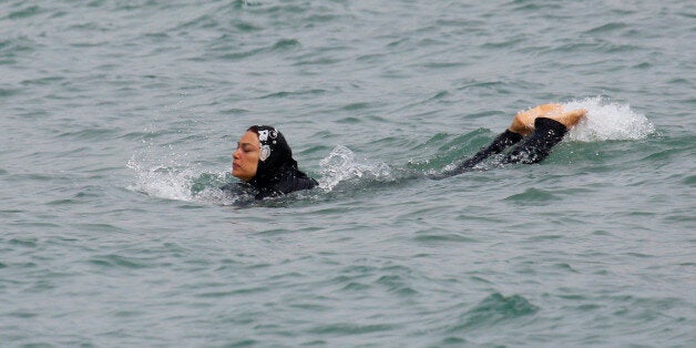 A Muslim woman wears a burkini, a swimsuit that leaves only the face, hands and feet exposed, as she swims in the Mediterranean Sea in Marseille, France, August 17, 2016. REUTERS/Stringer