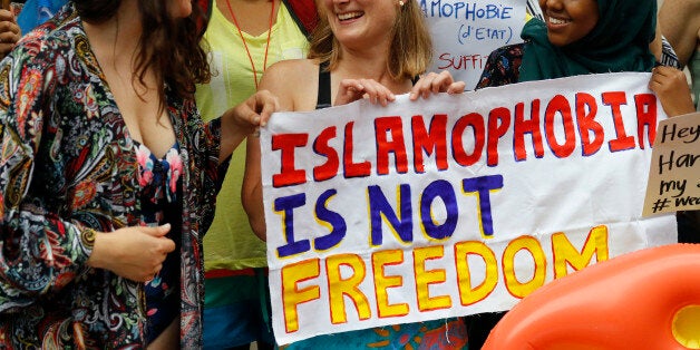 Activists protest outside the French embassy during, the "wear what you want beach party" in London, Thursday, Aug. 25, 2016. The protest is against the French authorities clampdown on Muslim women wearing burkinis on the beach. (AP Photo/Frank Augstein)