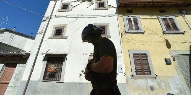 A firefighter walks in the hamlet of Torrita in Amatrice, on August 29, 2016, few days after an earthquake hit the area, a disaster that claimed nearly 300 lives. Shoddy, price-cutting renovations, in breach of local building regulations, could be partly to blame for the high death toll from this week's devastating earthquake in central Italy, according to a prosecutor investigating the disaster. / AFP / ANDREAS SOLARO (Photo credit should read ANDREAS SOLARO/AFP/Getty Images)