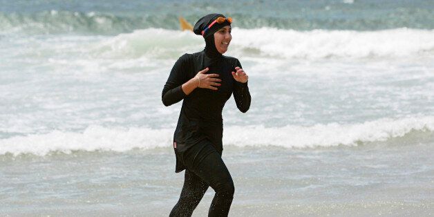 Twenty-year-old trainee volunteer surf life saver Mecca Laalaa runs along North Cronulla Beach in Sydney during her Bronze medallion competency test January 13, 2007. Specifically designed for Muslim women, Laalaa's body-covering swimming costume has been named the "burkini" by its Sydney based designer Aheda Zanetti. REUTERS/Tim Wimborne (AUSTRALIA)