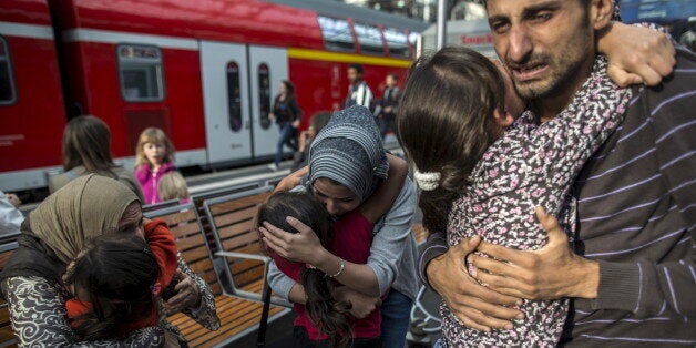 Ihab, 30 (R), a Syrian migrant from Deir al-Zor, cries as he and his familly are welcomed by his relatives upon their arrival