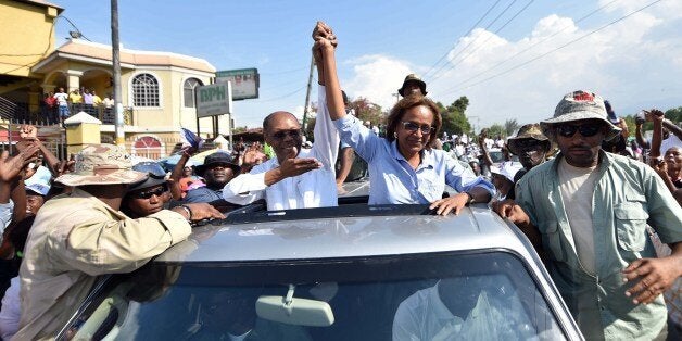 Presidential candidate Maryse Narcisse (C R) of the Fanmi Lavalas political party is joined by former Haitian President Jean-Bertrand Aristide (C L) during a rally in Port-au-Prince, Haiti, on October 23, 2015. The presidential elections will be held on October 25. AFP PHOTO/HECTOR RETAMAL (Photo credit should read HECTOR RETAMAL/AFP/Getty Images)