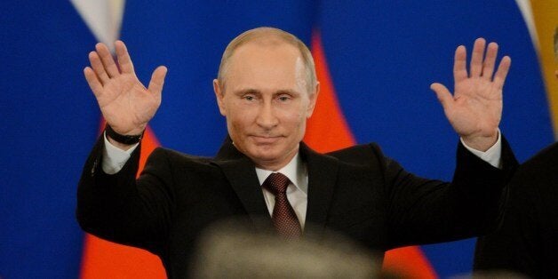 Russia's President Vladimir Putin gestures after signing a treaty on the Ukrainian Black Sea Crimea peninsula becoming part o