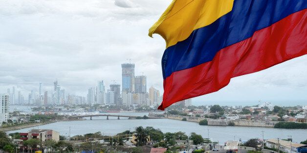 Colombian flag waving on the wind and modern Cartagena district behind it