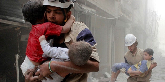 Members of the Civil Defence rescue children after what activists said was an air strike by forces loyal to Syria's President Bashar al-Assad in al-Shaar neighbourhood of Aleppo, Syria June 2, 2014. REUTERS/Sultan Kitaz/File Photo TPX IMAGES OF THE DAY 