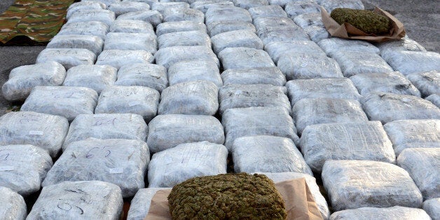 Macedonian customs officers pose for the media with hundreds of packages of marijuana which were seized at a border crossing, in Skopje, Macedonia, Tuesday, Nov. 27, 2012. Macedonian custom officers seized over 500 kilograms (1100 pounds) of marijuana at a Macedonian border crossing with neighboring Albania and detained the truck driver, police said. The marijuana, which is believed to have originated from Albania and destined for distribution in western Europe, has an estimated euro 3 million (US$ 3.8 million) street value. (AP Photo/Boris Grdanoski)