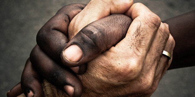 Black man and white man shaking hands in friendship. Close up of handshake. Homage to Mandela.