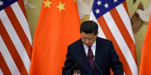 China's President Xi Jinping takes down notes as he speaks to media in front of U.S. and Chinese national flags during a joint news conference with U.S. President Barack Obama (not pictured) at the Great Hall of the People in Beijing November 12, 2014. REUTERS/Jason Lee (CHINA - Tags: POLITICS)