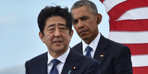 US President Barack Obama (R) listens as Japanese Prime Minister Shinzo Abe speaks at the USS Arizona Memorial on December 27