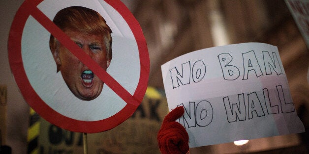 LONDON, ENGLAND - JANUARY 30: Demonstrators hold up placards during a protest outside Downing Street against U.S. President Donald Trump's ban on travel from seven Muslim countries on January 30, 2017 in London, England. President Trump signed an executive order on Friday banning immigration to the USA from seven Muslim countries. This led to protests across America and, today, in the UK, a British petition asking for the downgrading of Trump's State visit passed one million signatures this morning. (Photo by Jack Taylor/Getty Images)