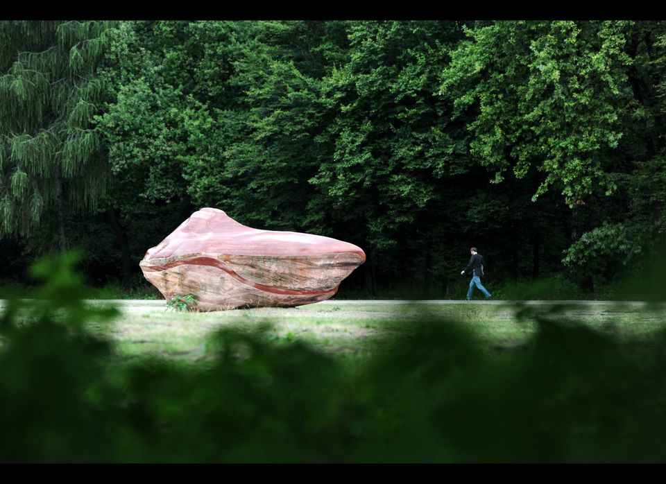A man walks past a stone of the "Global