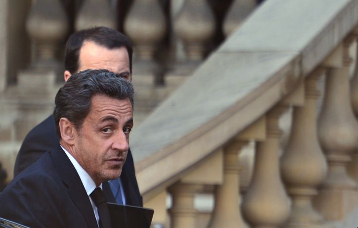 French former president Nicolas Sarkozy steps out of a car on March 25, 2013 in Paris, five days after being charged with taking financial advantage of L'Oreal heiress Liliane Bettencourt, as part of a probe into illegal party funding that could shatter his hopes of a political comeback. AFP PHOTO / MARTIN BUREAU (Photo credit should read MARTIN BUREAU/AFP/Getty Images)