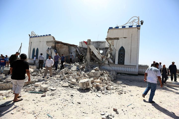 Libyan people walk through the debris and rubble of a damaged Sufi shrine in the neighbourhood of Tajoura, on the outskirts of Tripoli, after it was attacked during the early hours of the morning by unknown individuals on March 28, 2013. Unknown attackers planted and set off an explosive device, partially destroying the mausoleum of Sidi Mohamed Landoulsi, a 15th Century Sufi Theologist. AFP PHOTO/MAHMUD TURKIA (Photo credit should read MAHMUD TURKIA/AFP/Getty Images)