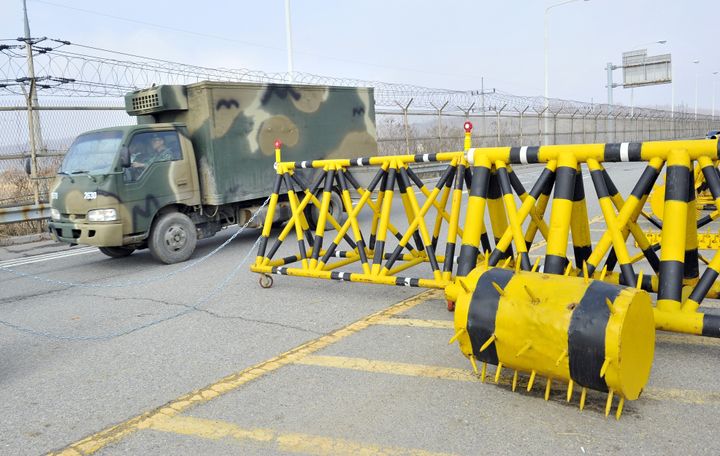 A South Korean military truck drives past barricades on the road linked to North Korea at a military check point in Paju near the demilitarized zone (DMZ) dividing the two Koreas on April 3, 2013. North Korea on April 3 delayed the entry of South Koreans to a joint industrial complex in a rare move amid high tensions on the Korean peninsula, the South's Unification Ministry said. AFP PHOTO / JUNG YEON-JE (Photo credit should read JUNG YEON-JE/AFP/Getty Images)
