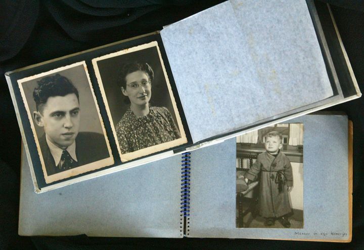 KIBBUTZ NAAN, ISRAEL - NOVEMBER 28: (ISRAEL OUT) Efraim Kochava is seen in a childhood album alongside photos of his parents Zigfried, left, and Marta Van-Coevorden, who were captured by the Nazis in the Dutch city of Amsterdam and who met their deaths in the Echterdingen World War Two forced labour camp, November 28, 2005 in Kochava's home in Kibbutz Naan in central Israel. In September 2005, a mass grave containing 34 skeletons believed to be from the camp was found during construction work at a U.S. Army base in Echterdingen and Israeli officials are approaching possible relatives in Israel for DNA samples to compare to those from the remains. Kochava, who never knew his parents when they were captured when he was one year old and who was saved from the Nazis by a Dutch couple, believes his father is amongst the 34 skeletons and if DNA tests prove positive, he hopes to bring his bones for burial in Israel. (Photo by Uriel Getty/Getty Images)