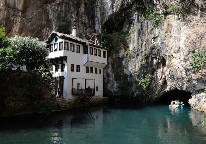 Tourists explore a cave on a boat near the source of the Buna river near the village of Blagaj, some 10 kilometers from southern Bosnian town of Mostar on July 10, 2010, next to the old Tekija house, made in 17th century under Ottoman empire influence. The source of the Buna river is an underground karstic spring, and one of the largest in Europe, producing approximately 30 m3 per second with cold and clean water. AFP PHOTO/HRVOJE POLAN (Photo credit should read HRVOJE POLAN/AFP/Getty Images)