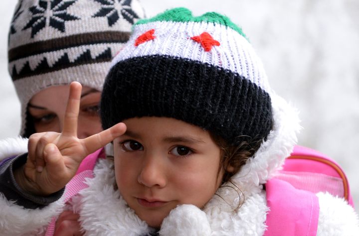 A displaced Syrian girl makes the victory sign as she leaves at the end of classes at a makeshift school in the Jabal al-Turkman mountain area in Syria's northern Latakia province on February 6, 2013. The United Nations has predicted the number of Syrian refugees in neighbouring countries will double to 1.1 million by June if Syria's 22-month conflict -- which it says has killed more than 60,000 people -- does not end. AFP PHOTO/AAMIR QURESHI (Photo credit should read AAMIR QURESHI/AFP/Getty Images)
