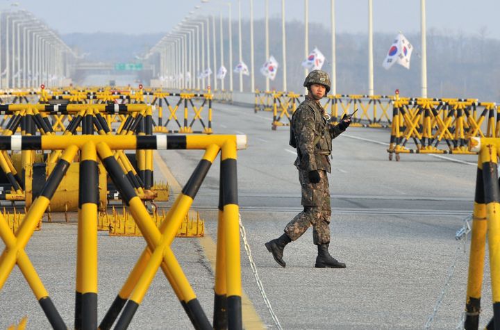 A South Korean soldier walks beside barricades on a road leading to North Korea's Kaesong joint industrial complex, at a military checkpoint in the border city of Paju on April 8, 2013. South Korea said on April 7 that 13 South Korean firms had been forced to suspend production at a joint industrial zone in North Korea and warned of a 'critical' situation if Pyongyang continued to ban access to the site. AFP PHOTO / JUNG YEON-JE (Photo credit should read JUNG YEON-JE/AFP/Getty Images)