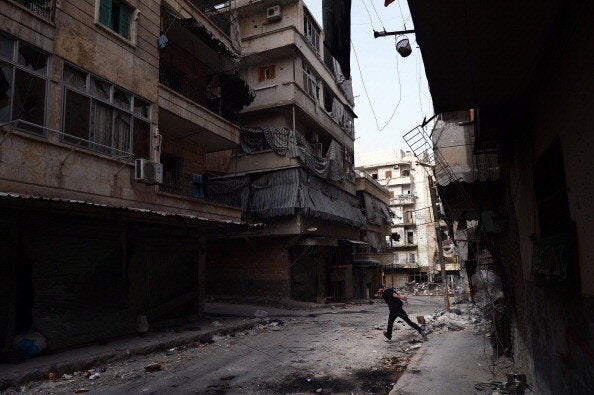 A Syrian rebel fighter runs across a street to avoid snipers of government forces in the Saladin district of the northern Syrian city of Aleppo on April 8, 2013. AFP PHOTO / DIMITAR DILKOFF (Photo credit should read DIMITAR DILKOFF/AFP/Getty Images)