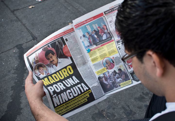 A man reads a newspaper on the victory of the new Venezuelan president Nicolas Maduro on April 15, 2013. Venezuela's acting President Nicolas Maduro declared victory on Sunday in the race to succeed late leader Hugo Chavez after the electoral council announced that he had won in a close battle. AFP PHOTO/RONALDO SCHEMIDT (Photo credit should read Ronaldo Schemidt/AFP/Getty Images)