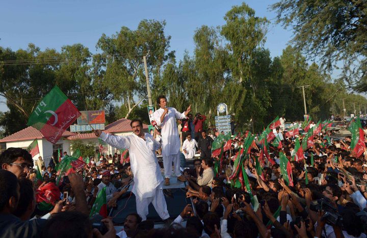 Pakistan cricket star turned politician Imran Khan (C) addresses supporters as he stands on a vehicle during a rally in Mianwali, northern Pakistan, on October 6, 2012. Pakistani cricketer turned politician Imran Khan led Western activists and thousands of supporters on a defiant march to the tribal belt to protest against US drone strikes. Crowds lined the road to greet Khan, and scrums of media and well-wishers thronged his 4X4 as the convoy of more than 100 vehicles embarked on the 440-kilometre (270-mile) drive from Islamabad to South Waziristan. AFP PHOTO / A MAJEED (Photo credit should read A Majeed/AFP/GettyImages)