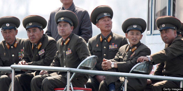 SINUIJU, NORTH KOREA - APRIL 10: (CHINA OUT) North Korean military officers sit onboard a ship at the frontier between China