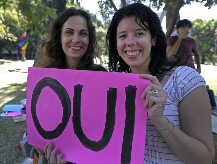 Two women hold a sign reading 'Oui' ('Yes' in French) during a demonstration in support of the legalisation of gay marriage and LGBT (lesbian, gay, bisexual, and transgender) parenting in France at the Plaza Francia in Buenos Aires, on January 27, 2013. AFP PHOTO/Alejandro PAGNI (Photo credit should read ALEJANDRO PAGNI/AFP/Getty Images)