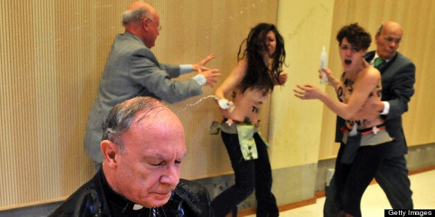 Archbishop Andre-Joseph Leonard sits drenched in water after members of women's rights movement Femen protesting against homophobia gate-crash a lecture on blasphemy by Leonard on April 23, 2013 at the ULB university in Brussels. AFP PHOTO / GEORGE GOBET (Photo credit should read GEORGE GOBET/AFP/Getty Images)