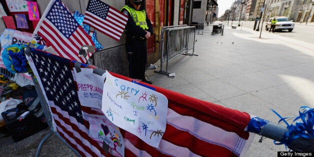 BOSTON, MA - APRIL 22: A Boston Police officer bows his head during a moment of silence near the Boston Marathon finish line on one week anniversary of the bombings on April 22, 2013 in Boston, Massachusetts. A manhunt ended for Dzhokhar A. Tsarnaev, 19, a suspect in the Boston Marathon bombing after he was apprehended on a boat parked on a residential property in Watertown, Massachusetts. His brother Tamerlan Tsarnaev, 26, the other suspect, was shot and killed after a car chase and shootout with police. The bombing, on April 15 at the finish line of the marathon, killed three people and wounded at least 170. (Photo by Kevork Djansezian/Getty Images)