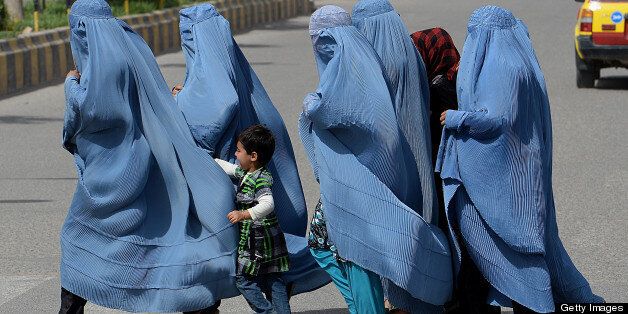 A group of burqa-clad Afghan women cross a road in Herat early April 21, 2013. Afghanistan has made some progress in using the law to protect women against violence but many still suffer horrific abuse despite 11 years of Western intervention, a UN report on December 2012 showed. AFP PHOTO/ SHAH Marai (Photo credit should read SHAH MARAI/AFP/Getty Images)