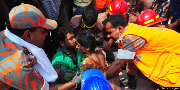 Bangladeshi firefighters rescue a garment worker (C) found alive in the collapse of an eight-storey building in Savar, on the outskirts of Dhaka, on April 25, 2013. The death toll in the Bangladesh's worst industrial disaster reached 200 people after rescue workers pulled out scores more corpses from the rubble of a collapsed garment factory building. AFP PHOTO/ STR (Photo credit should read STR/AFP/Getty Images)
