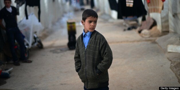 An internally displaced Syrian boy stands near tents in the Maiber al-Salam refugee camp along the Turkish border in the northern province of Aleppo on April 17, 2013. UN agencies helping to care for the millions driven from their homes in Syria by two years of conflict warned that they face 'impossible' choices as funding fails to meet soaring needs. In all, some 1.3 million people have now fled Syria and some 200,000 more are crossing into neighbouring countries each month. AFP PHOTO / DIMITAR DILKOFF (Photo credit should read DIMITAR DILKOFF/AFP/Getty Images)