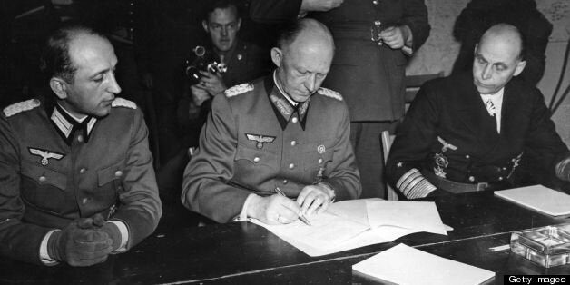 General Alfred Jodl (1890 - 1946) Hitler's military advisor, controller of German High Command and chief of the Operations Staff (centre), signs the document of surrender (German Capitulation) of the German armed forces at Reims in General Eisenhower's headquarters. He is joined by Major Wilhelm Oxenius (left) and Hans Georg von Friedeburg, Admiral of the Fleet (right). Original Publication: People Disc - HF0475 (Photo by Keystone/Getty Images)