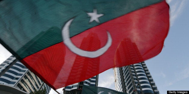 A supporter of Pakistani politician and former cricketer Imran Khan waves the party flag during an election campaign rally in