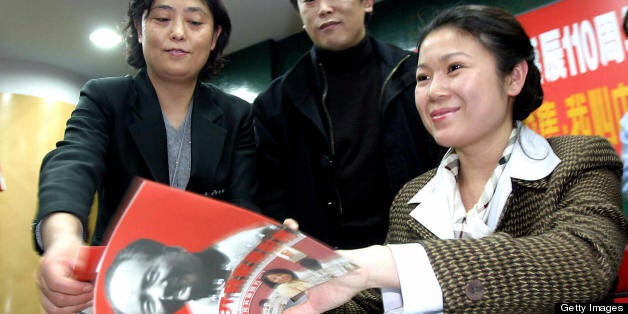 BEIJING, CHINA: Granddaughter of the late Chinese revolutionary Mao Zedong, Kong Dongmei (R) signs copies of the new pictorial book on the life of her grandfather, at a bookstore in Beijing 20 December 2003. The revolutionary and often brutal leader, born on December 26, 1893, has long been praised for establishing the People's Republic of China in 1949, as China prepares to dust off an updated version of the cult of personality for the 110th anniversary of the birth of the late revolutionary Mao Zedong, with a new hip-hop song, films, books and concerts. AFP PHOTO (Photo credit should read STR/AFP/Getty Images)