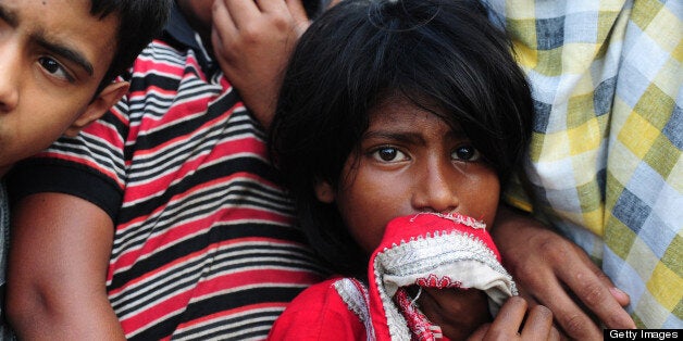 Onlookers gather during the funeral of garment workers killed in the garment factory collapse at a graveyard in Dhaka on May