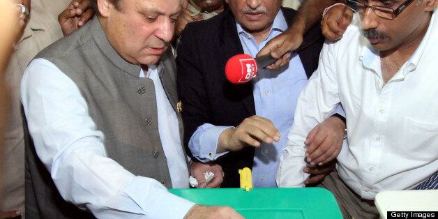 Former Pakistani prime minister Nawaz Sharif (L), casts his vote at a polling station in Lahore on May 11, 2013. Sharif, the frontrunner in Pakistan's landmark election, cast his ballot on May 11 and said he was confident of victory. The vote marks the first time that an elected civilian administration has completed a full term and handed power to another through the ballot box in a country where there have been three military coups and four military rulers. AFP PHOTO / ARIF ALI (Photo credit should read Arif Ali/AFP/Getty Images)