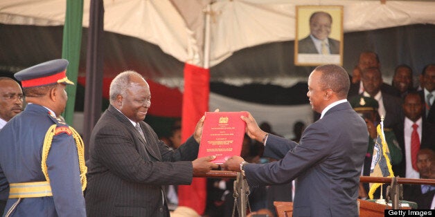 NAIROBI, KENYA - APRIL 9: (KENYA, UGANDA, RWANDA and TANZANIA OUT) Outgoing President Kibaki hands over the Constitution of Kenya to President Uhuru Kenyatta after he was sworn in as Kenyan's 4th President on April 9, 2013 in Nairobi, Kenya. Kenyatta received masses of support from the citizens of Kenya despite being under investigation for crimes against humanity. (Photo by William Oeri/ Nation Media/Gallo Images/Getty Images)