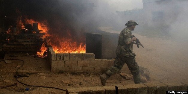 AFP EXCLUSIVE Syrian army soldiers take control of the village of Western Dumayna, some seven kilometers north of the rebel-held city of Qusayr on May 13, 2013. Syrian troops captured three villages in the strategic Qusayr area of Homs province, allowing them to cut supply lines to rebels inside Qusayr town, a military officer told AFP. AFP PHOTO/JOSEPH EID (Photo credit should read JOSEPH EID/AFP/Getty Images)